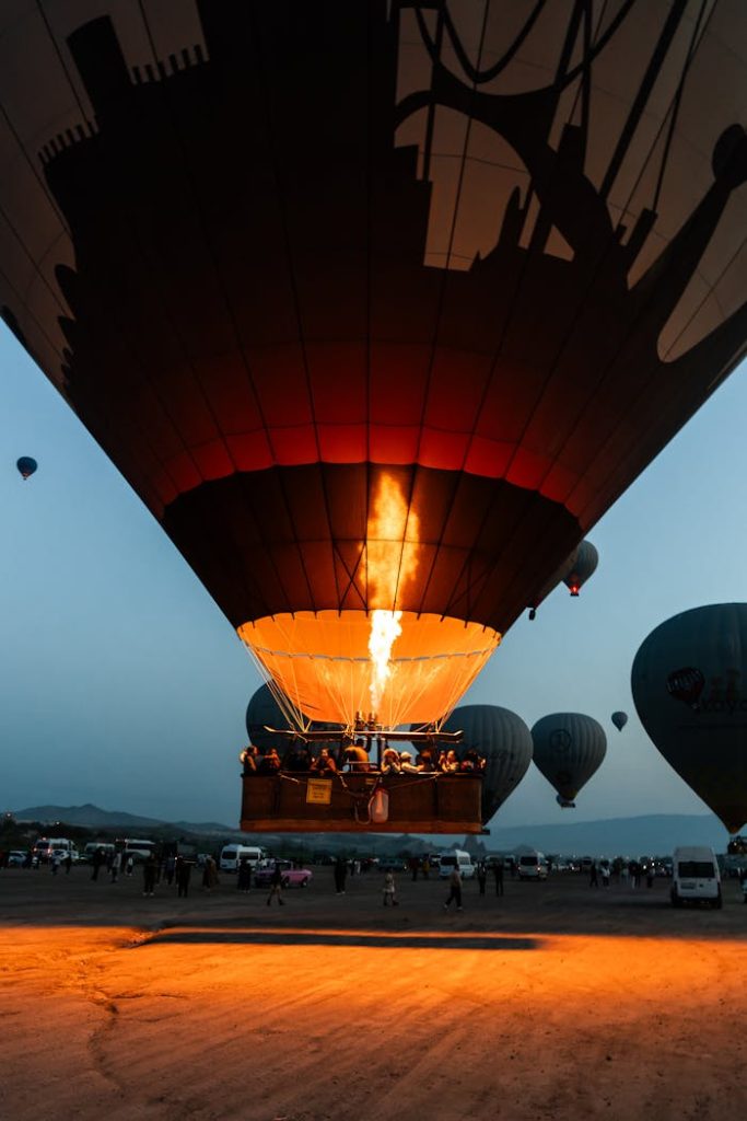 Dramatic view of hot air balloons igniting at dusk, ready for takeoff.